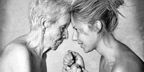 Schwarzweißfoto einer alten Frau und einer jungen Frau, die ihre Stirn vorbeugen und sich an den Händen halten - Bild zum Thema Botox