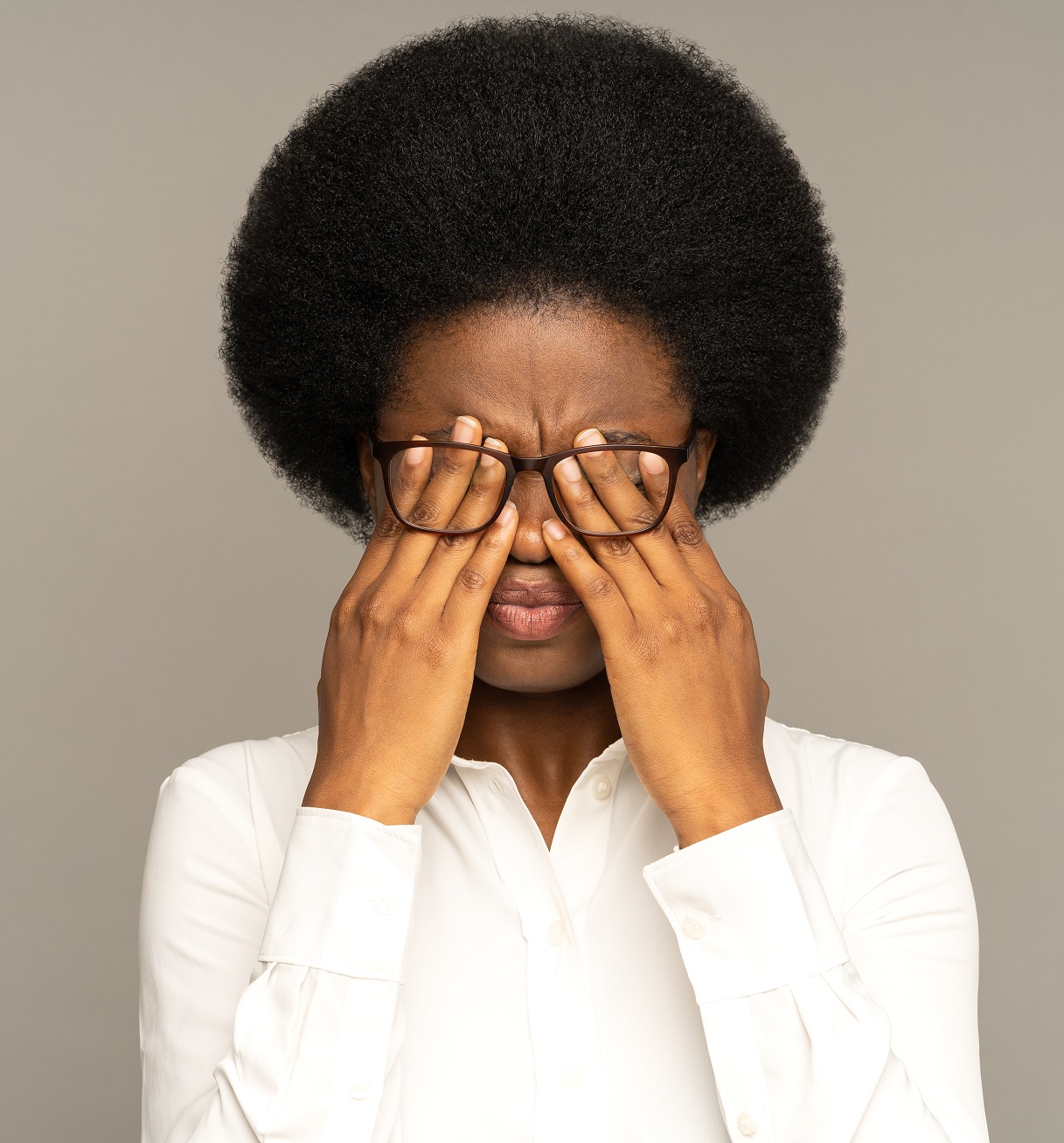 Afroamerkanische Frau reibt sich die Augen. Bild zum Thema: Für wen ist eine Lidkorrektur geeignet?