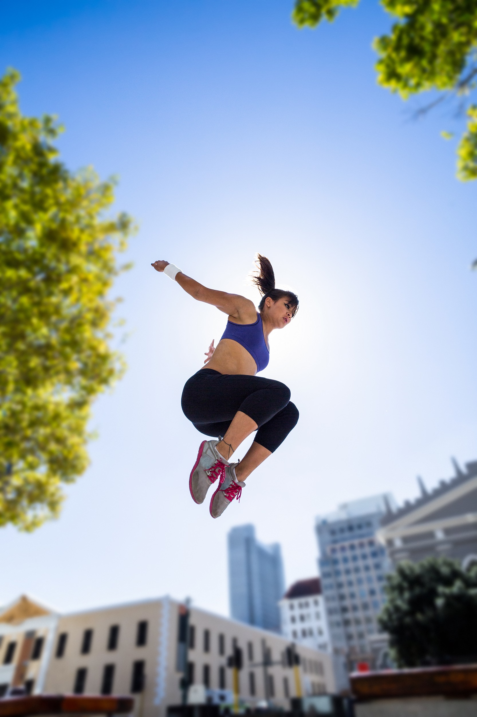 sportliche Frau springt in die Luft in der Stadt